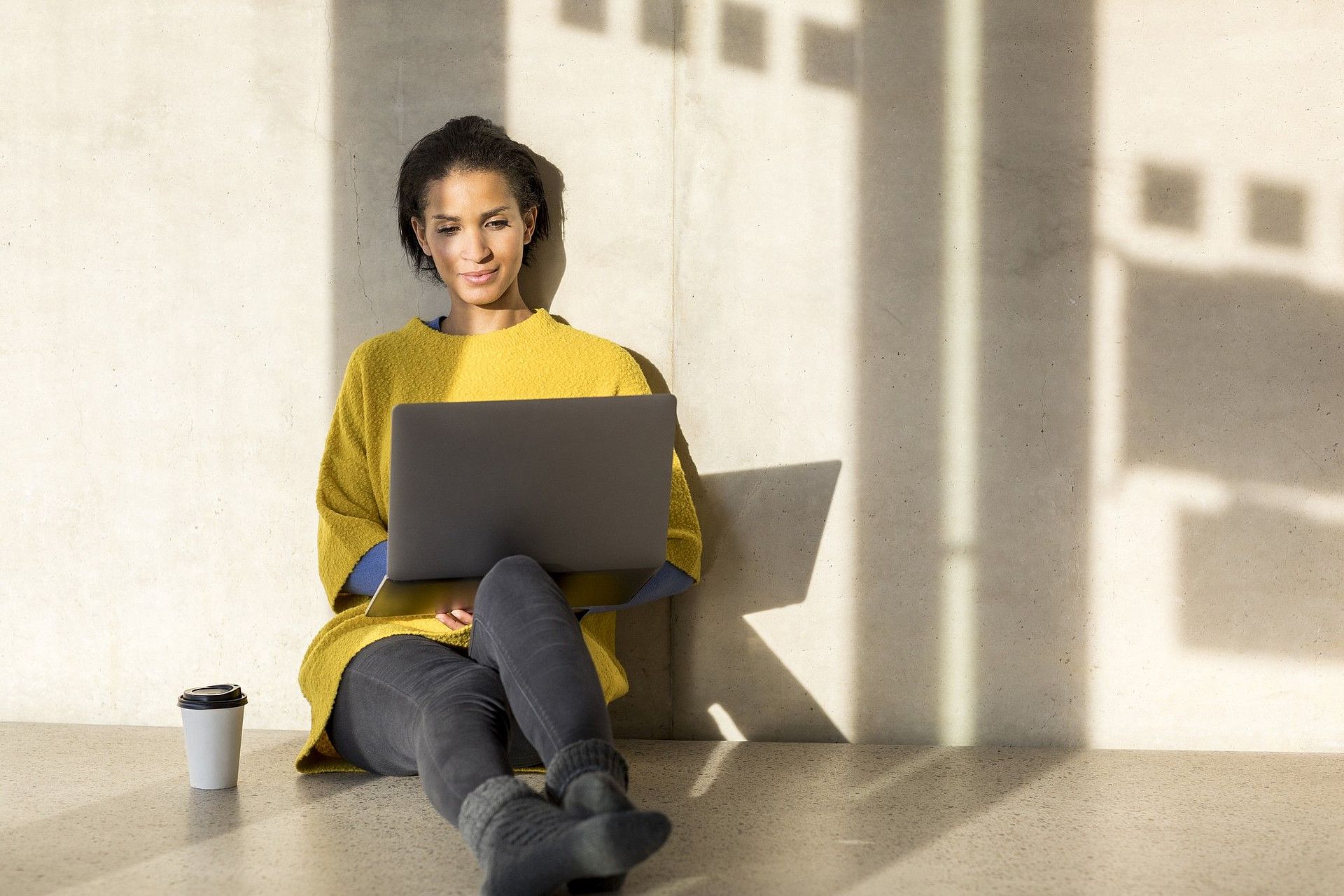 Frau schaut tippt und schaut in Laptop