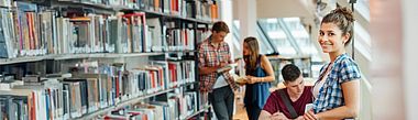 Studentin steht in Bibliothek