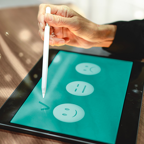 Eine Person tippt mit einem Stift auf einem Tablet.