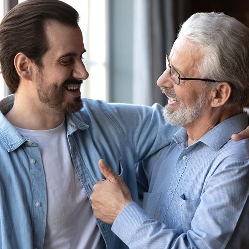 Ein Vater guckt seinem erwachsenen Sohn in die Augen.