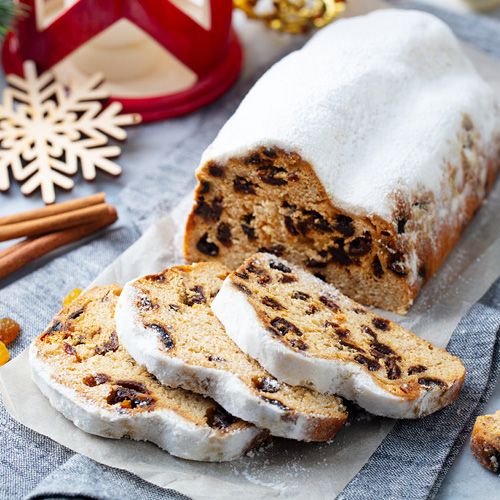 Ein Weihnachtsstollen liegt in Scheiben geschnitten auf einem Tisch