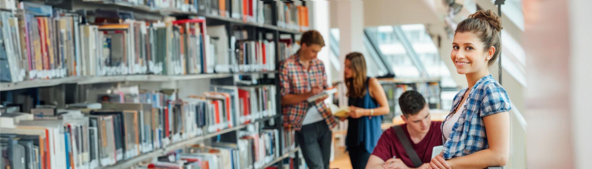 Studentin steht in Bibliothek